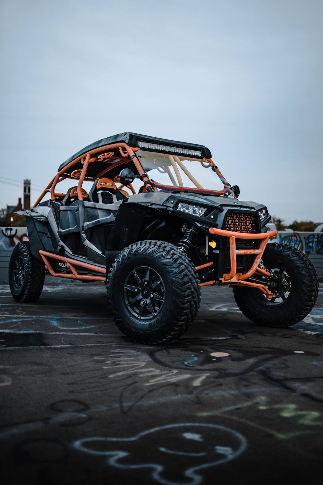 A sport side-by-side UTV with a roll cage and light bar